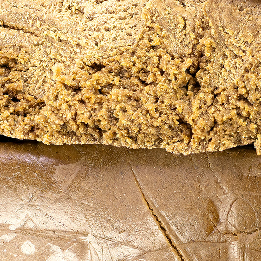Close-up of solventless bubble hash showing granular structure and golden color