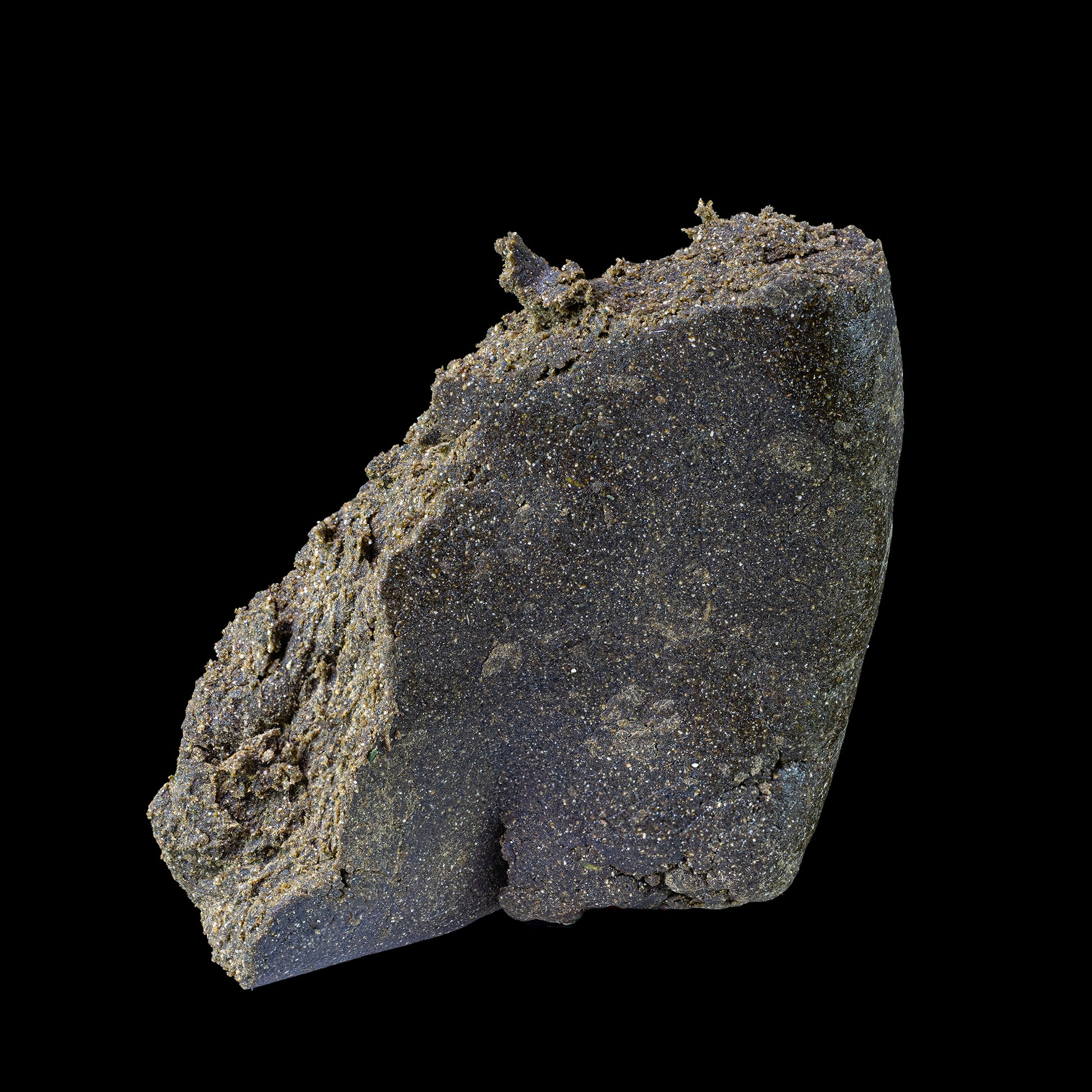 Makrooptagelse af Manali Hash med tydelig, krystallinsk struktur og olieret overflade i mørk brun farve med gyldne nuancer. Teksturen fremstår cremet, tæt og rig på trichomer, hvilket signalerer høj kvalitet og håndværksmæssig forarbejdning.